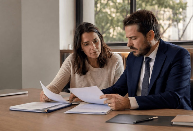 Início 3 Beneficiária e advogado comparam contrato, negativa e relatório médico durante análise jurídica de negativa de cobertura.